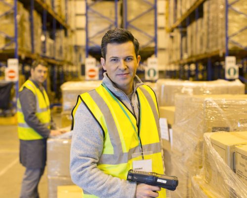 Worker scanning boxes in warehouse